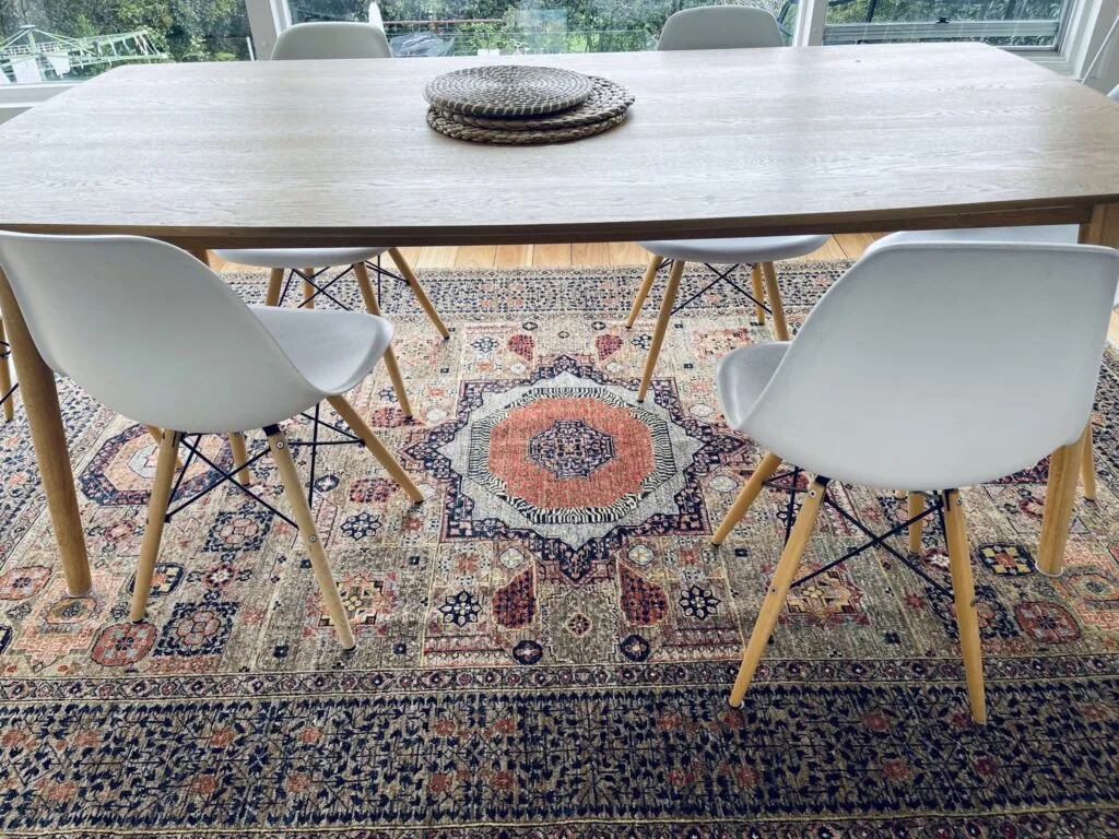 Medallion rug under a timber dining table with white chairs
